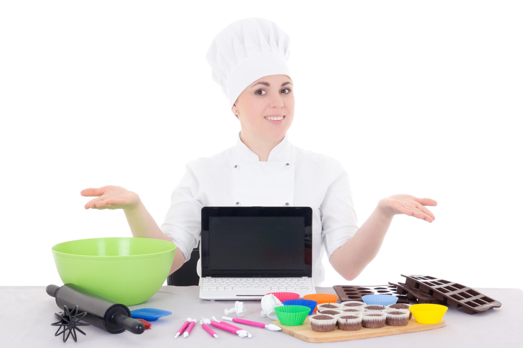 Chef che insegna a studente tramite laptop in cucina