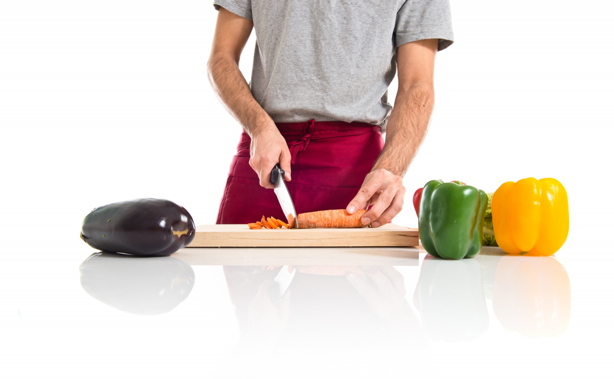 Chef che affetta verdure su tagliere in cucina moderna